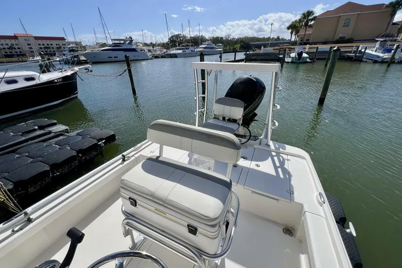Slide: The Image of 2021 Mako 21 LTS boat docked in marina, featuring comfortable seating and outboard motor. - 45