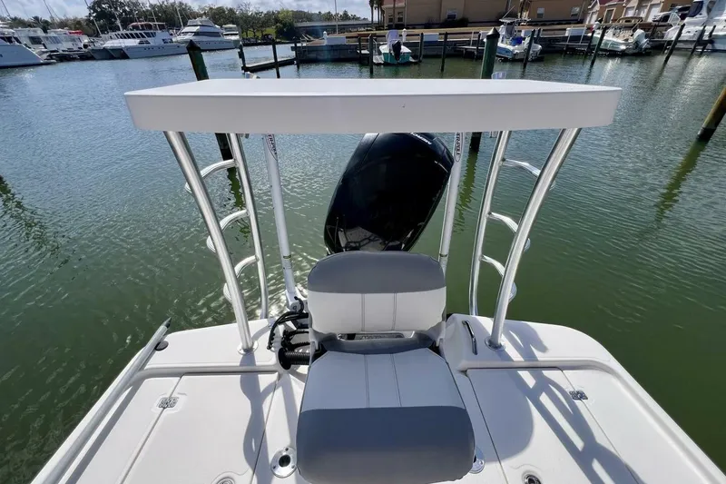 Slide: The Image of 2021 Mako 21 LTS boat with T-top and outboard motor in marina setting. - 50