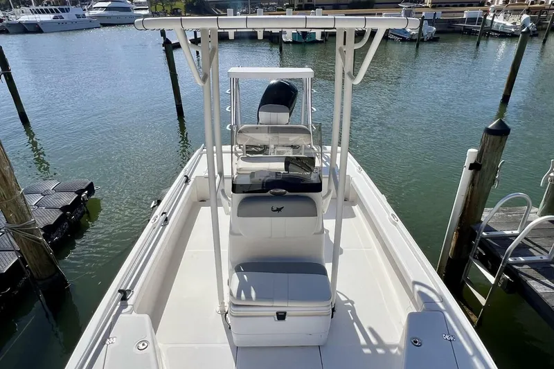 Slide: The Image of 2021 Mako 21 LTS boat docked in a marina, showcasing spacious deck and seating. - 6