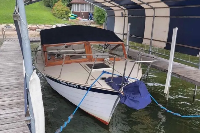 The Image of 1990 Skiff Craft 26' Runabout docked under a canopy. - 1