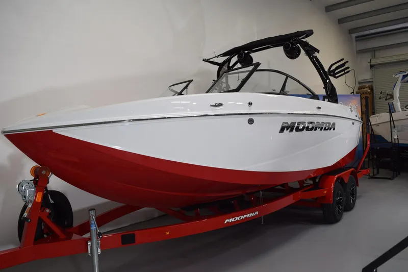 Slide: The Image of 2026 Moomba Craz boat with red and white design on a trailer in a showroom. - 17