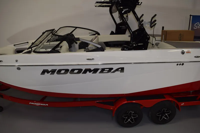 Slide: The Image of 2026 Moomba Craz boat with red trailer, side view in showroom. - 18