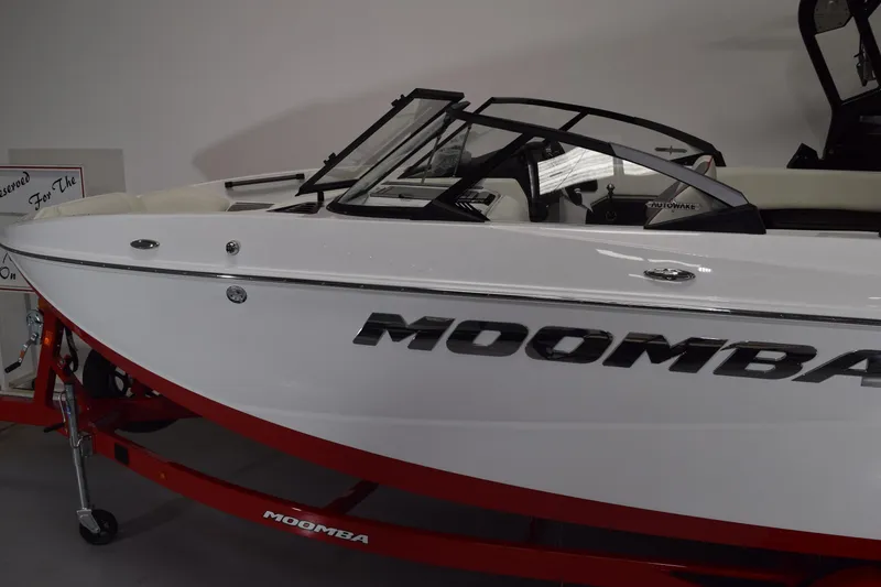 Slide: The Image of 2026 Moomba Craz boat with sleek white design and red trailer. - 2
