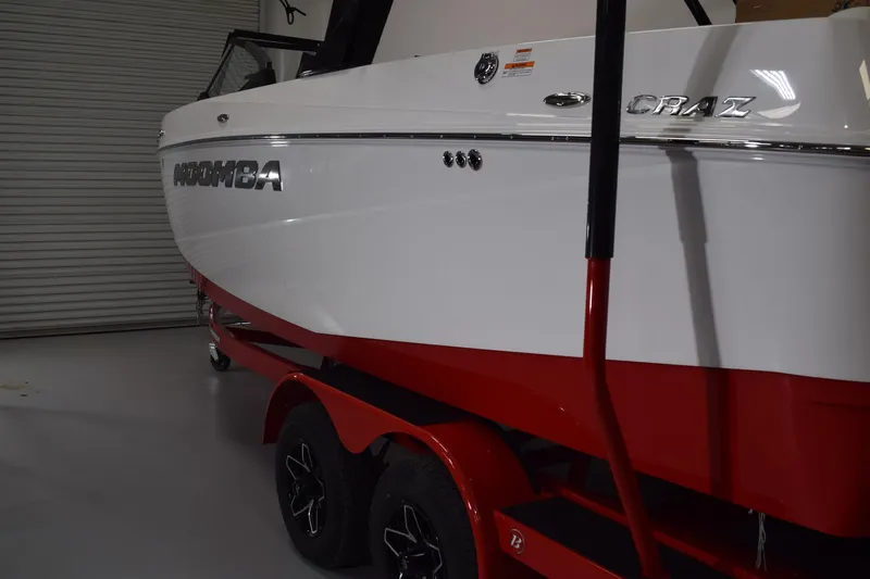 Slide: The Image of 2026 Moomba Craz boat with red trailer in a garage setting. - 20
