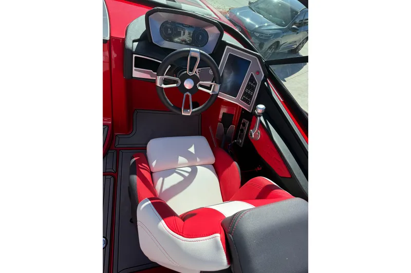Slide: The Image of 2022 MasterCraft X26 boat cockpit with red and white seating, modern steering, and digital controls. - 11