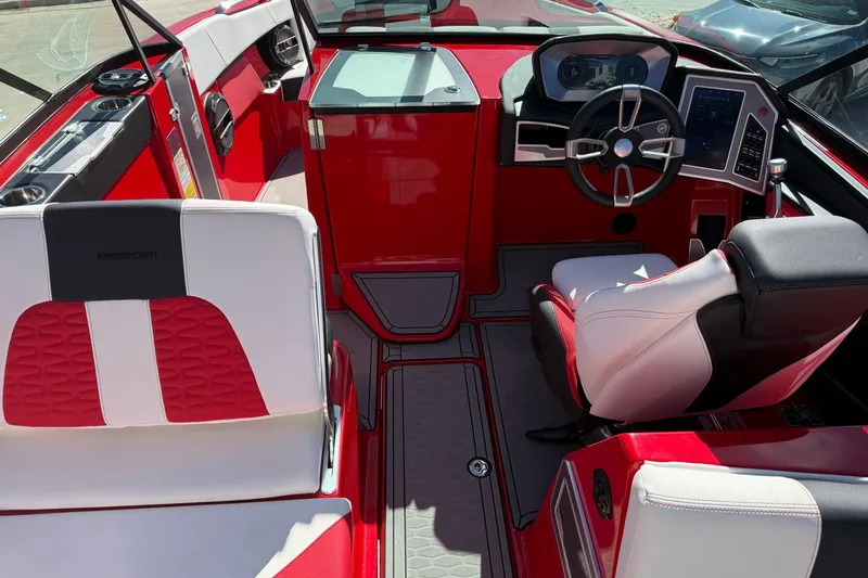 Slide: The Image of 2022 MasterCraft X26 boat interior with red and white seating, modern dashboard, and steering wheel. - 12