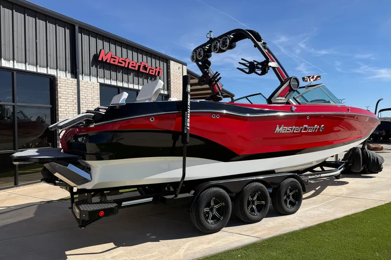 Slide: The Image of 2022 MasterCraft X26 boat in red and black, parked outside dealership. - 19