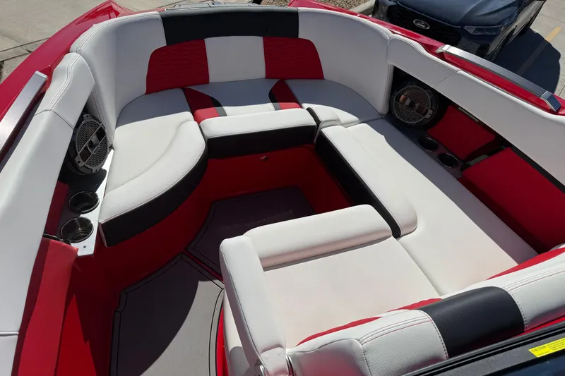Slide: The Image of 2022 MasterCraft X26 boat interior with red and white seating, cup holders, and speakers. - 6