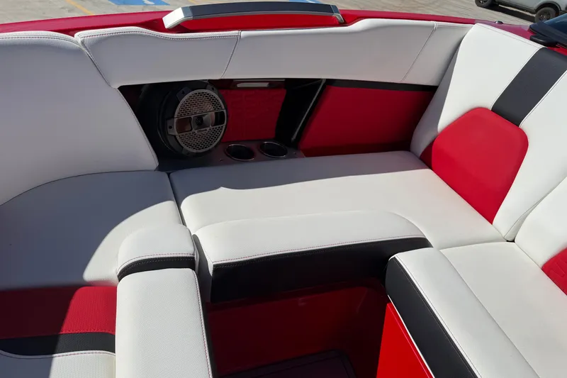Slide: The Image of 2022 MasterCraft X26 boat interior with red and white seating and speaker system. - 9