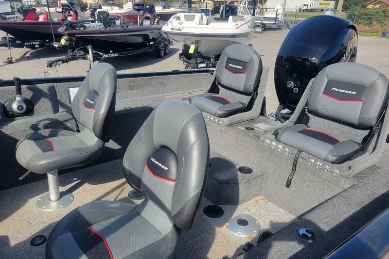 Slide: The Image of 2022 Tracker Pro Guide V-175 Combo boat interior with seating and motor, parked outdoors. - 13