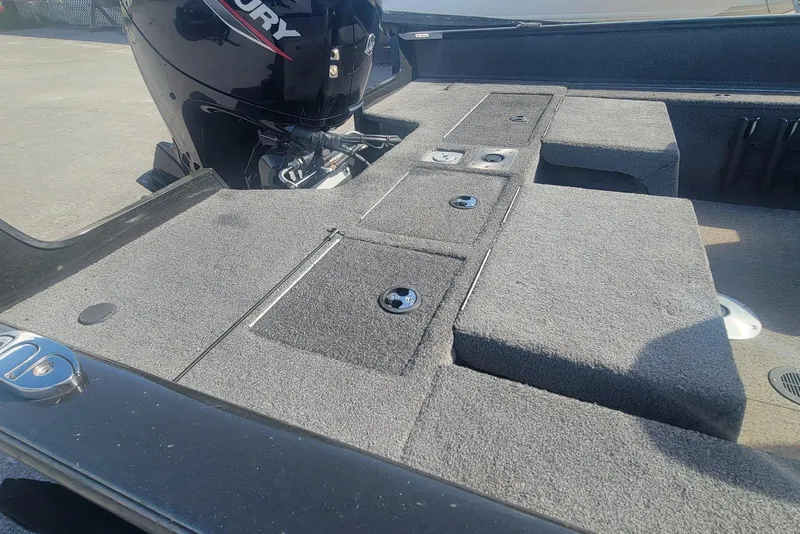 Slide: The Image of 2022 Tracker Pro Guide V-175 Combo boat interior with Mercury engine, featuring carpeted storage compartments. - 8