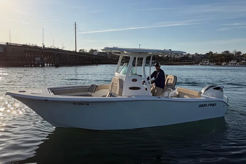 Slide: The Image of 2023 Sea Pro 239 Center Console boat on water, with a person at the helm. - 10