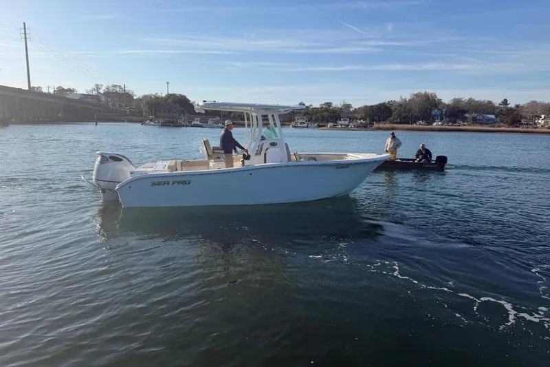 Slide: The Image of 2023 Sea Pro 239 Center Console boat on calm water, with two people onboard. - 11