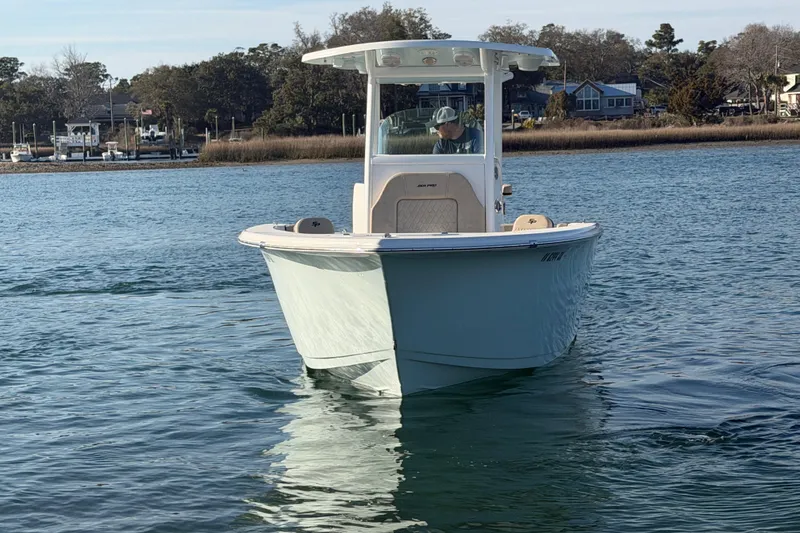 Slide: The Image of 2023 Sea Pro 239 Center Console boat cruising on calm water near a marina. - 17
