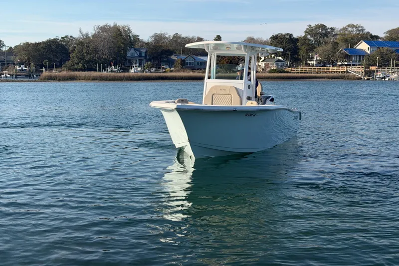 Slide: The Image of 2023 Sea Pro 239 Center Console boat cruising on a calm lake near shoreline. - 18