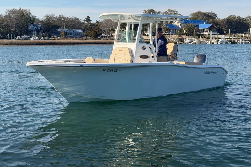 Slide: The Image of 2023 Sea Pro 239 Center Console boat on calm water, with a person at the helm. - 19