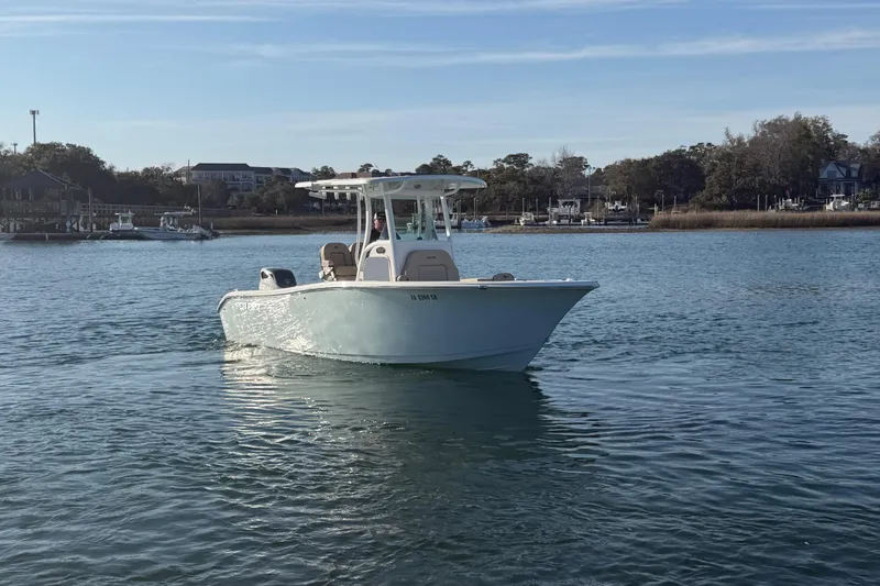 Slide: The Image of 2023 Sea Pro 239 Center Console boat on calm water near a marina. - 26