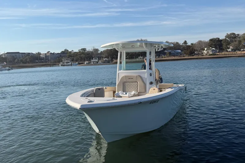 Slide: The Image of 2023 Sea Pro 239 Center Console boat on calm water, scenic shoreline background. - 28