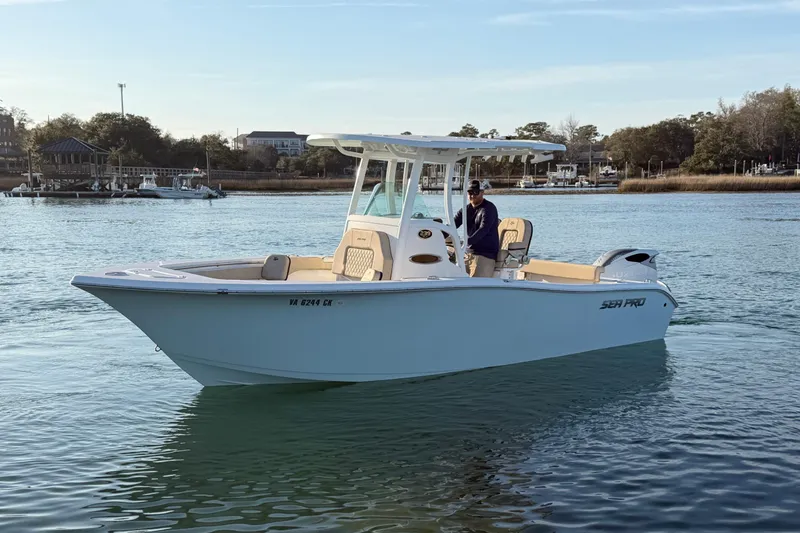 Slide: The Image of 2023 Sea Pro 239 Center Console boat on calm water, with a person at the helm. - 3
