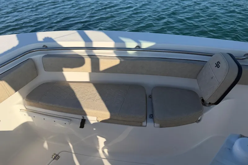 Slide: The Image of 2023 Sea Pro 239 Center Console boat seating area with beige cushions on water. - 38