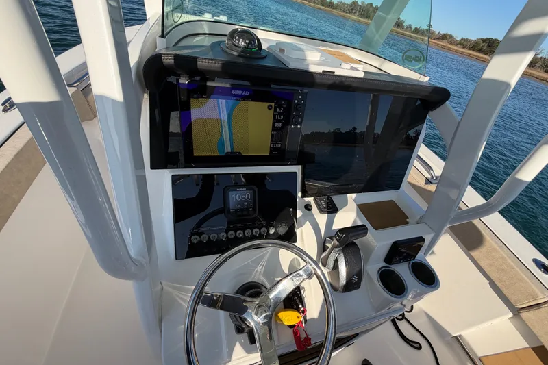 Slide: The Image of 2023 Sea Pro 239 Center Console boat dashboard with navigation equipment and steering wheel. - 53