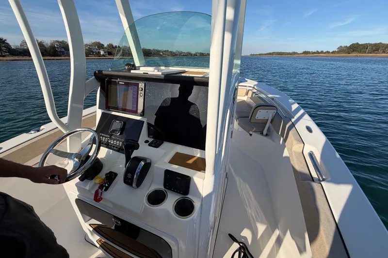 Slide: The Image of 2023 Sea Pro 239 Center Console boat on water, featuring modern dashboard and steering. - 55