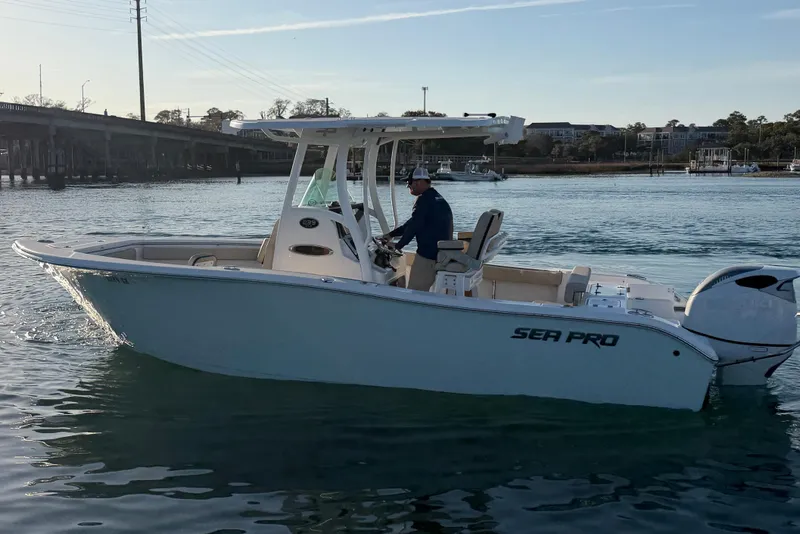 Slide: The Image of 2023 Sea Pro 239 Center Console boat cruising on calm waters near a bridge. - 9