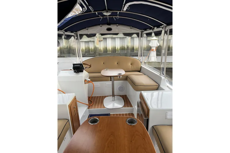 Slide: The Image of 2021 Duffy Cuddy Cabin 22 interior with tan seating and wooden table. - 4