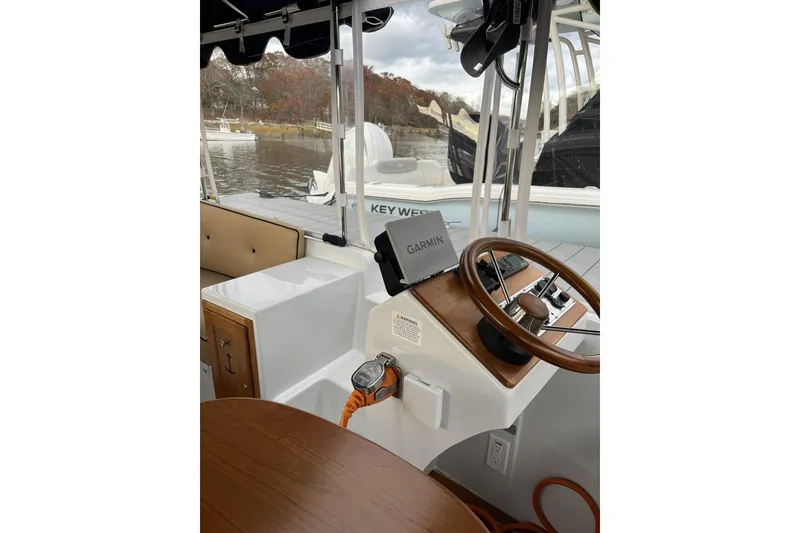 Slide: The Image of 2021 Duffy Cuddy Cabin 22 boat interior with Garmin navigation system and wooden steering wheel. - 5