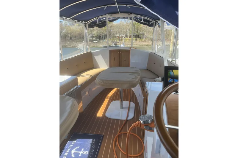 Slide: The Image of 2021 Duffy Cuddy Cabin 22 interior with seating, table, and navigation equipment. - 6