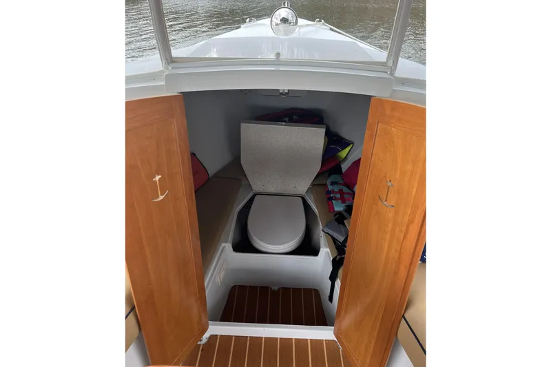 Slide: The Image of 2021 Duffy Cuddy Cabin 22 interior with wooden doors and compact toilet. - 7