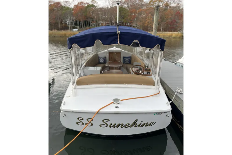Slide: The Image of 2021 Duffy Cuddy Cabin 22 boat named "SS Sunshine" docked with blue canopy. - 9