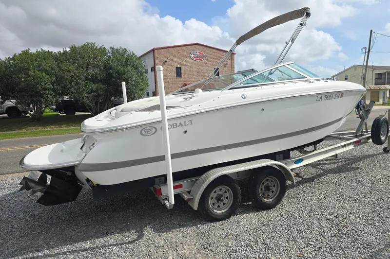 Slide: The Image of 2007 Cobalt 212 boat on trailer, parked on gravel, under cloudy sky. - 4