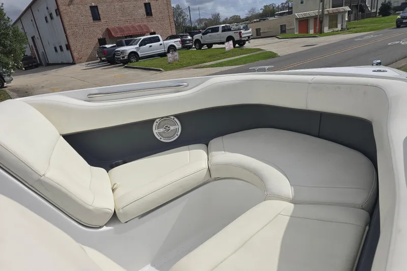 Slide: The Image of Interior of 2007 Cobalt 212 boat with white seating and speaker, parked near buildings. - 8