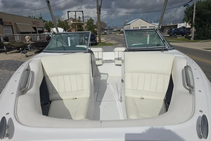 Slide: The Image of 2007 Cobalt 212 boat interior with white seating, parked outdoors under cloudy skies. - 9