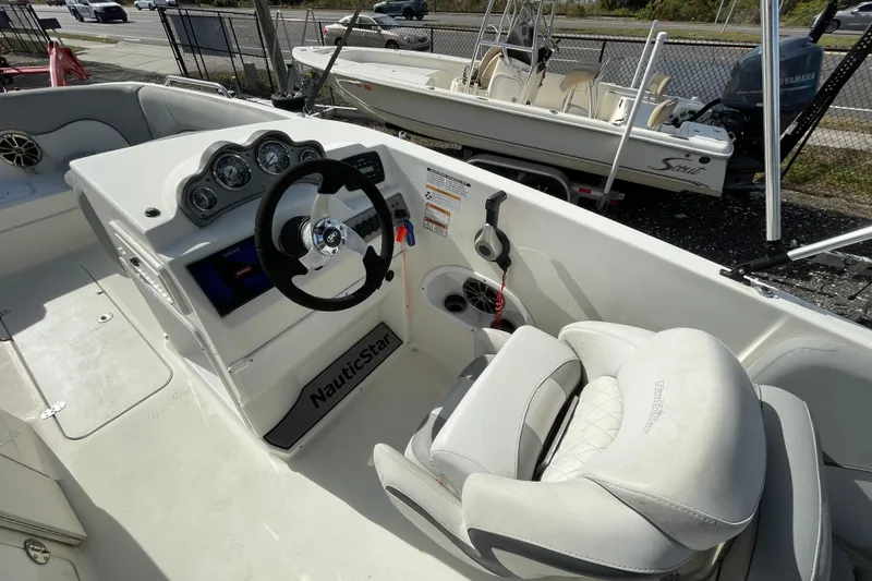 Slide: The Image of 2022 NauticStar 223 DC boat interior with steering wheel and dashboard controls. - 5