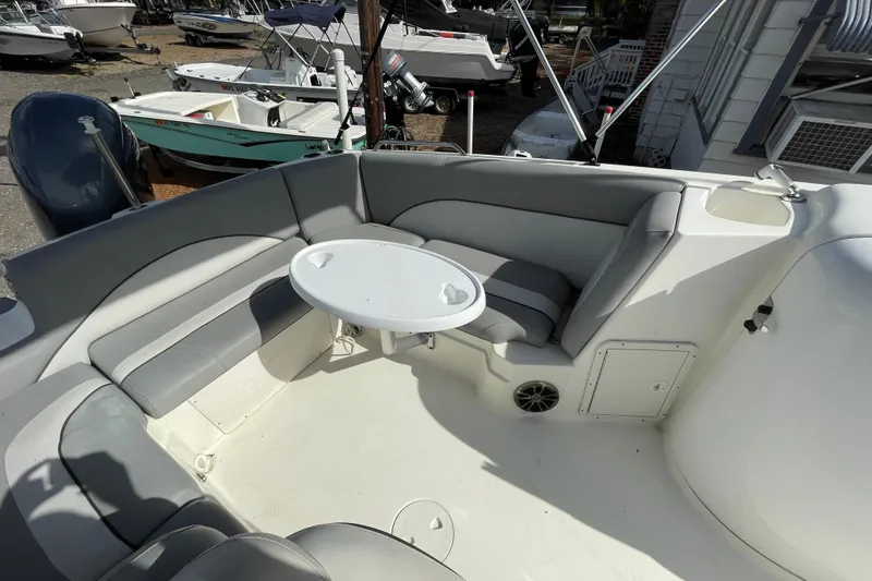 Slide: The Image of 2022 NauticStar 223 DC boat interior with seating and table, docked among other boats. - 7