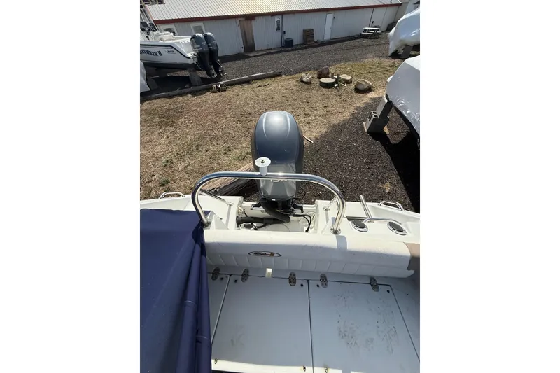 Slide: The Image of 2011 Sea Hunt Escape 220 LE boat with outboard motor, docked on land. - 24