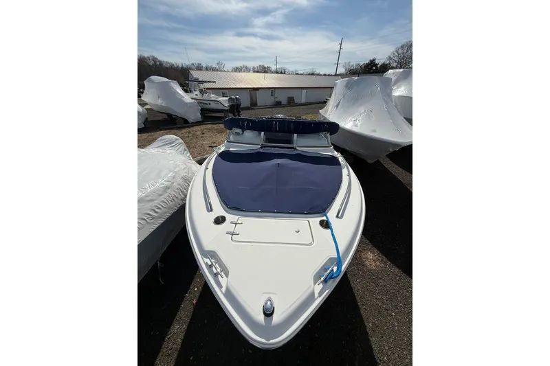 Slide: The Image of 2011 Sea Hunt Escape 220 LE boat with blue cover, parked outdoors. - 26