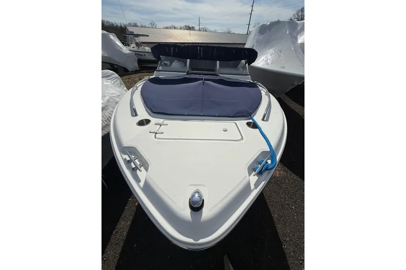 Slide: The Image of 2011 Sea Hunt Escape 220 LE boat with blue cover, docked outdoors. - 27