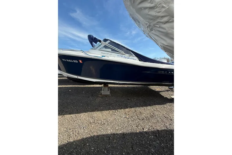 Slide: The Image of 2011 Sea Hunt Escape 220 LE boat on dry land under a clear blue sky. - 6