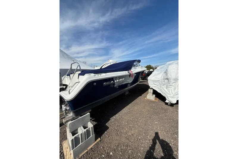 Slide: The Image of 2011 Sea Hunt Escape 220 LE boat on blocks under a clear blue sky. - 7