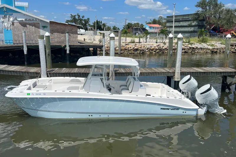 The Image of 2022 Twin Vee 280 GFX CC boat docked with dual engines, clear sky background. - 0