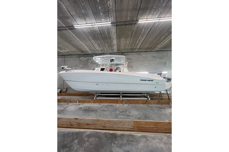 Slide: The Image of 2022 Twin Vee 280 GFX CC boat in a warehouse setting. - 4