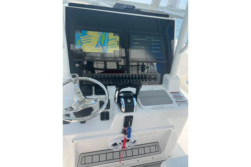 Slide: The Image of 2022 Twin Vee 280 GFX CC boat dashboard with navigation screens and controls. - 6