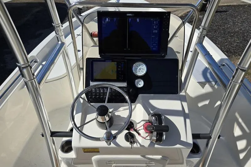 Slide: The Image of 2022 Bulls Bay 2200 boat dashboard with steering wheel, gauges, and navigation screens. - 12