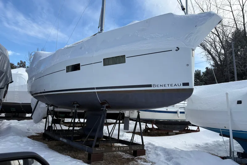 Slide: The Image of 2015 Beneteau Oceanis 35 sailboat covered in snow, stored on stands outdoors. - 10