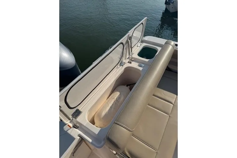 Slide: The Image of 2015 Pursuit DC 265 Dual Console boat interior with storage compartment open. - 10