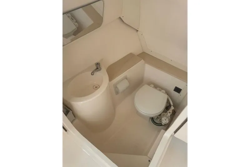 Slide: The Image of 2015 Pursuit DC 265 Dual Console boat bathroom with sink and toilet. - 11