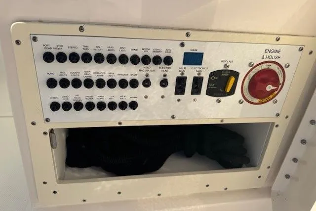 Slide: The Image of Control panel of a 2015 Pursuit DC 265 Dual Console boat, featuring switches and storage. - 12